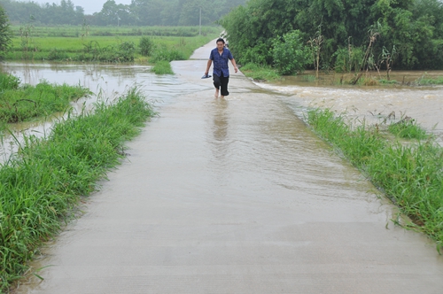 7月14日，事發(fā)路段，村民趟水過橋。此時(shí)沒頂?shù)暮樗呀?jīng)退去，一切仿佛歸于平靜.jpg